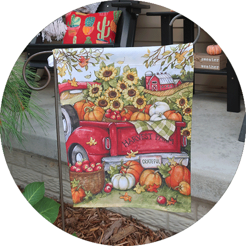 A garden flag with an old red truck on it.